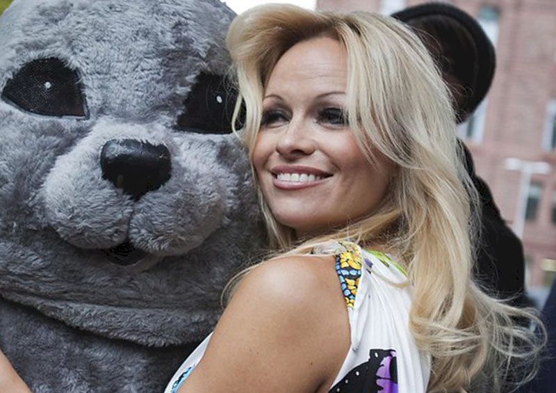 Pamela Anderson is standing with an animator