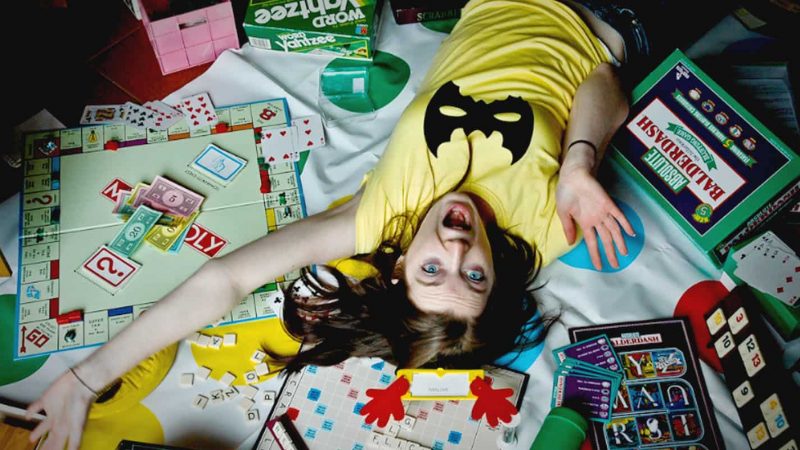A girl lies on a monopoly game board